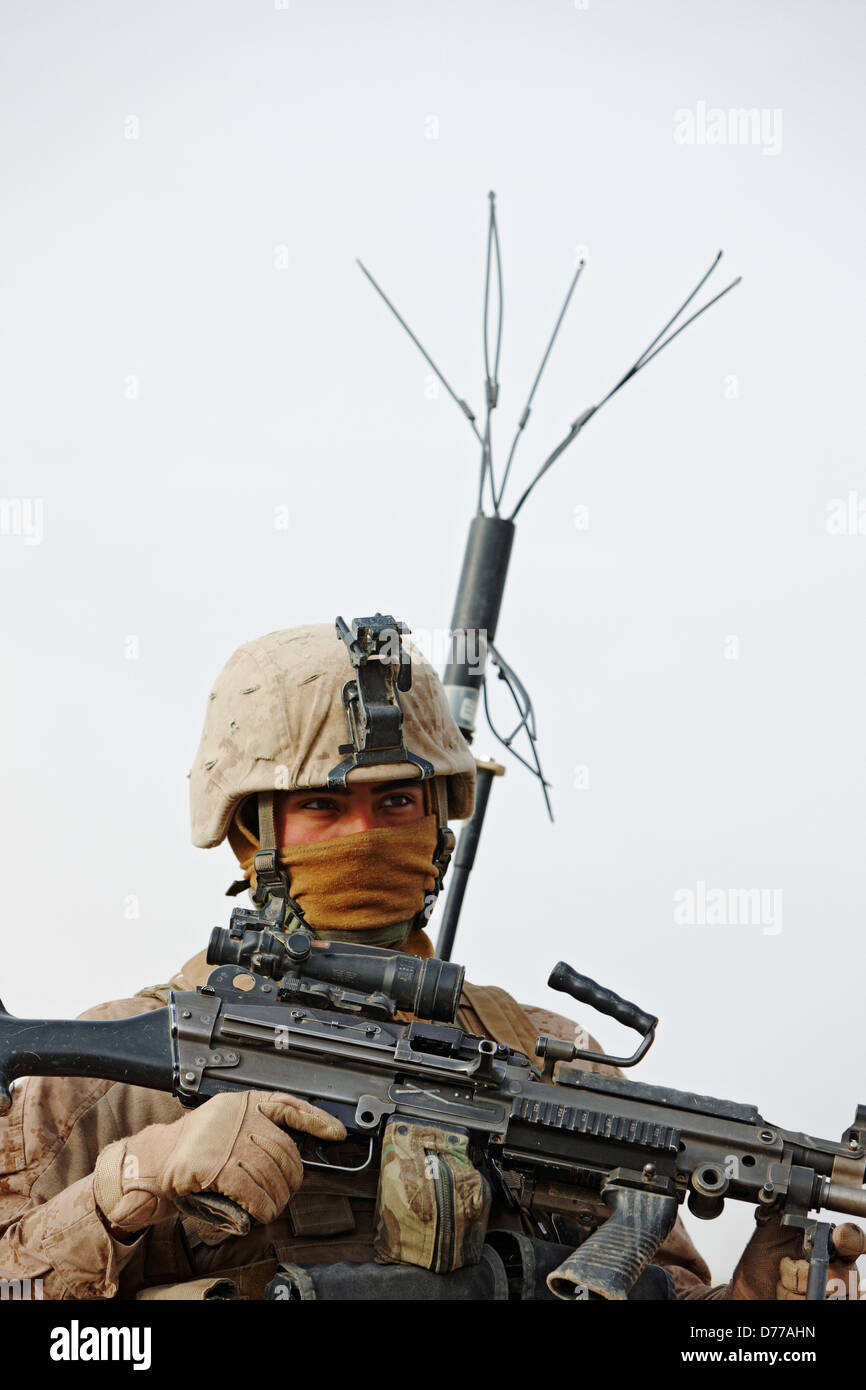 A U.S Marine Holds M249 Squad Automatic Weapon or SAW Wears Electronic Countermeasures Device to Block Remote Triggering Stock Photo