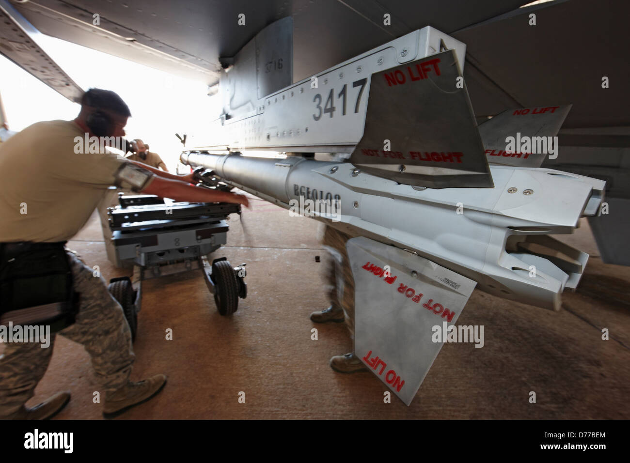 Ground Crewmen Load Missile onto Wing F-16 Stock Photo