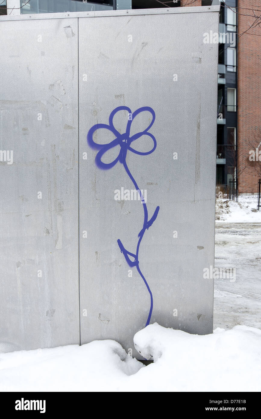 Sprayed purple flower on metal structure appearing to grow up out of the snow, Arabia, Helsinki Stock Photo