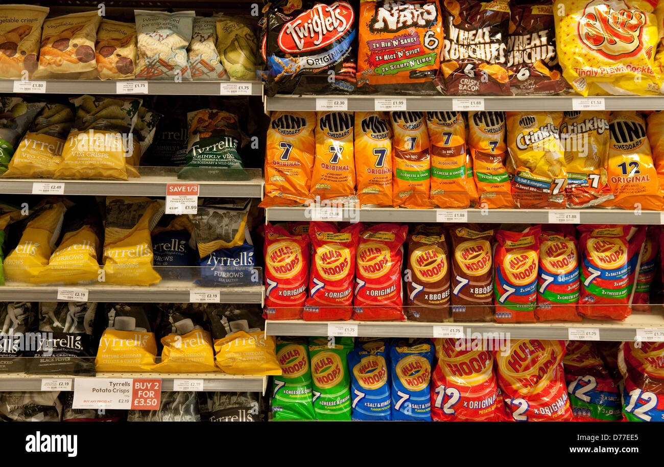 Bags of crisps and savoury snacks for sale on the supermarket shelves, Waitrose, Suffolk UK Stock Photo