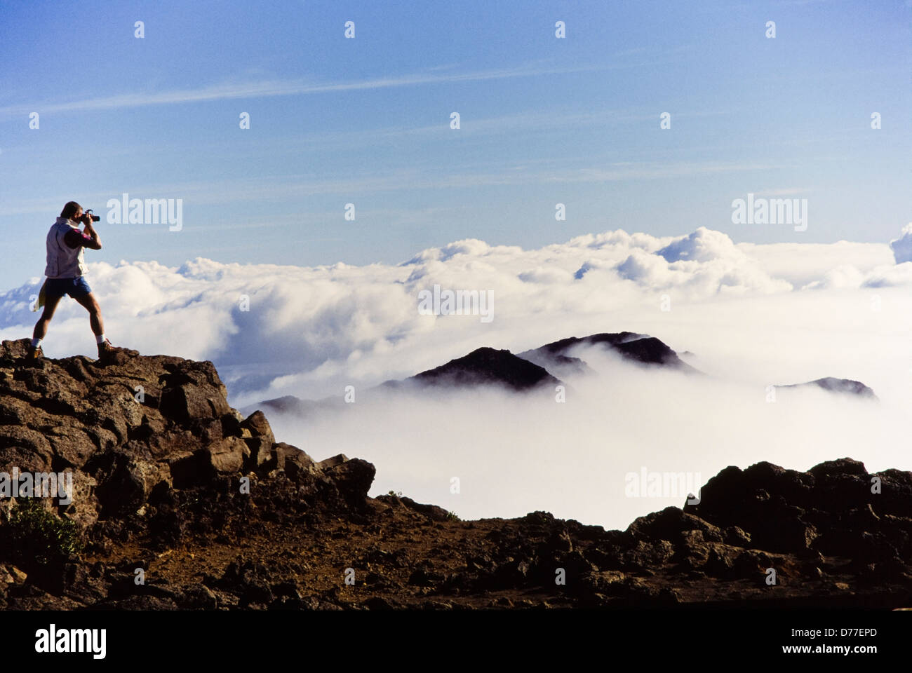 Mountain Climbing Photographer shoots sunrise image above clouds