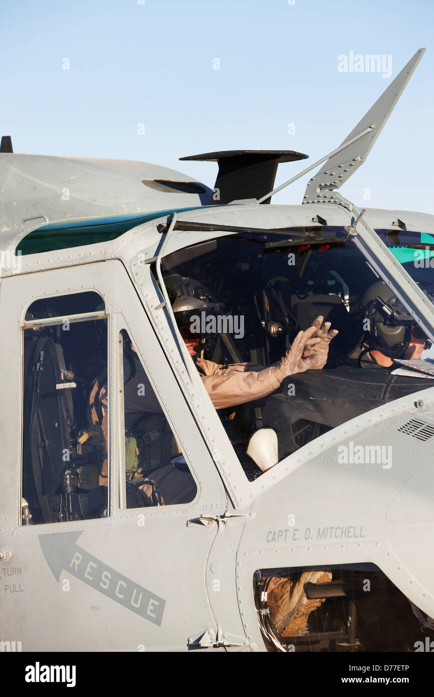 United States Marine Corps aviators raise their hands during weapons arming on their UH-1Y Venom helicopter preparing to launch Stock Photo
