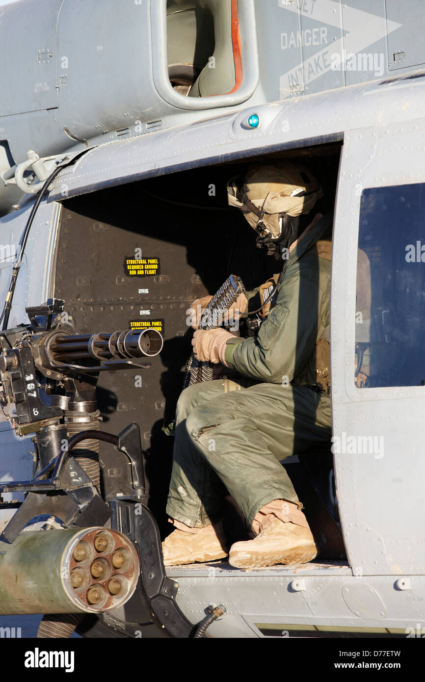 United States Marine gunner aboard UH-1Y Venom helicopter just prior to launching on combat operation in Helmand Province Stock Photo