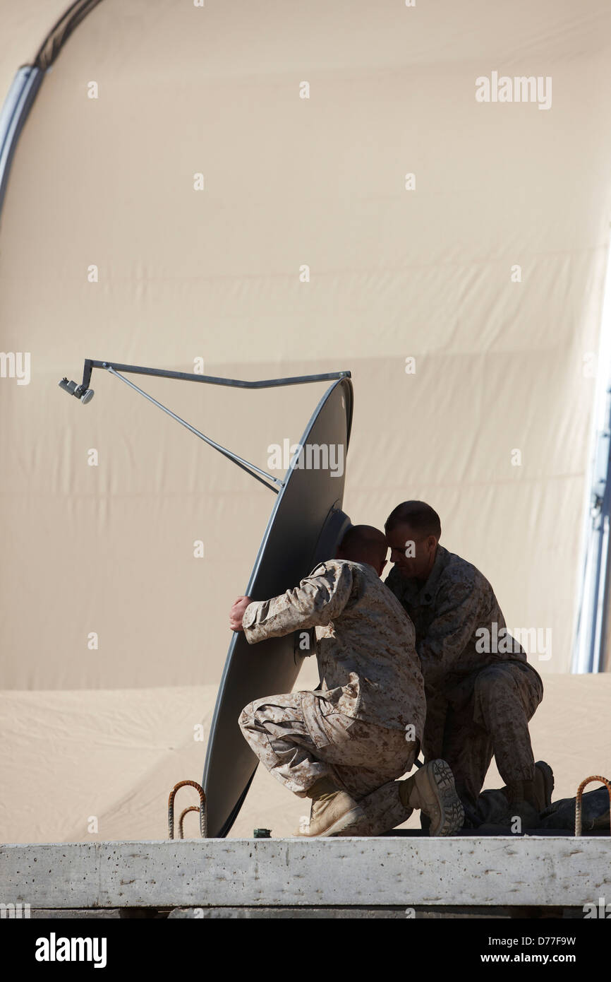 United States Marines set up parabolic satellite dish satellite antenna Camp Bastion Helmand Province Afghanistan Stock Photo