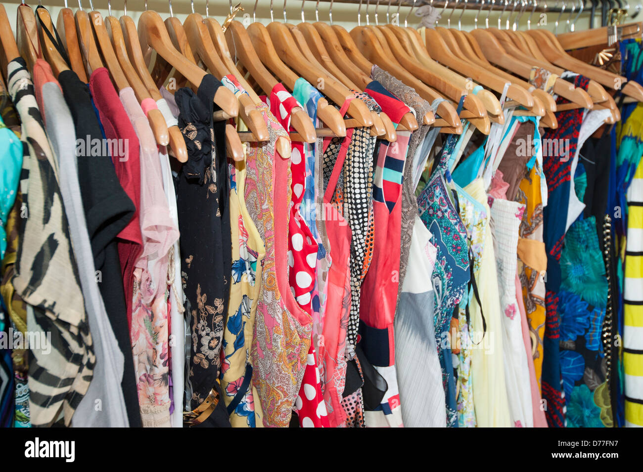 Various multicolored items of clothing hanging on hangers and rail in