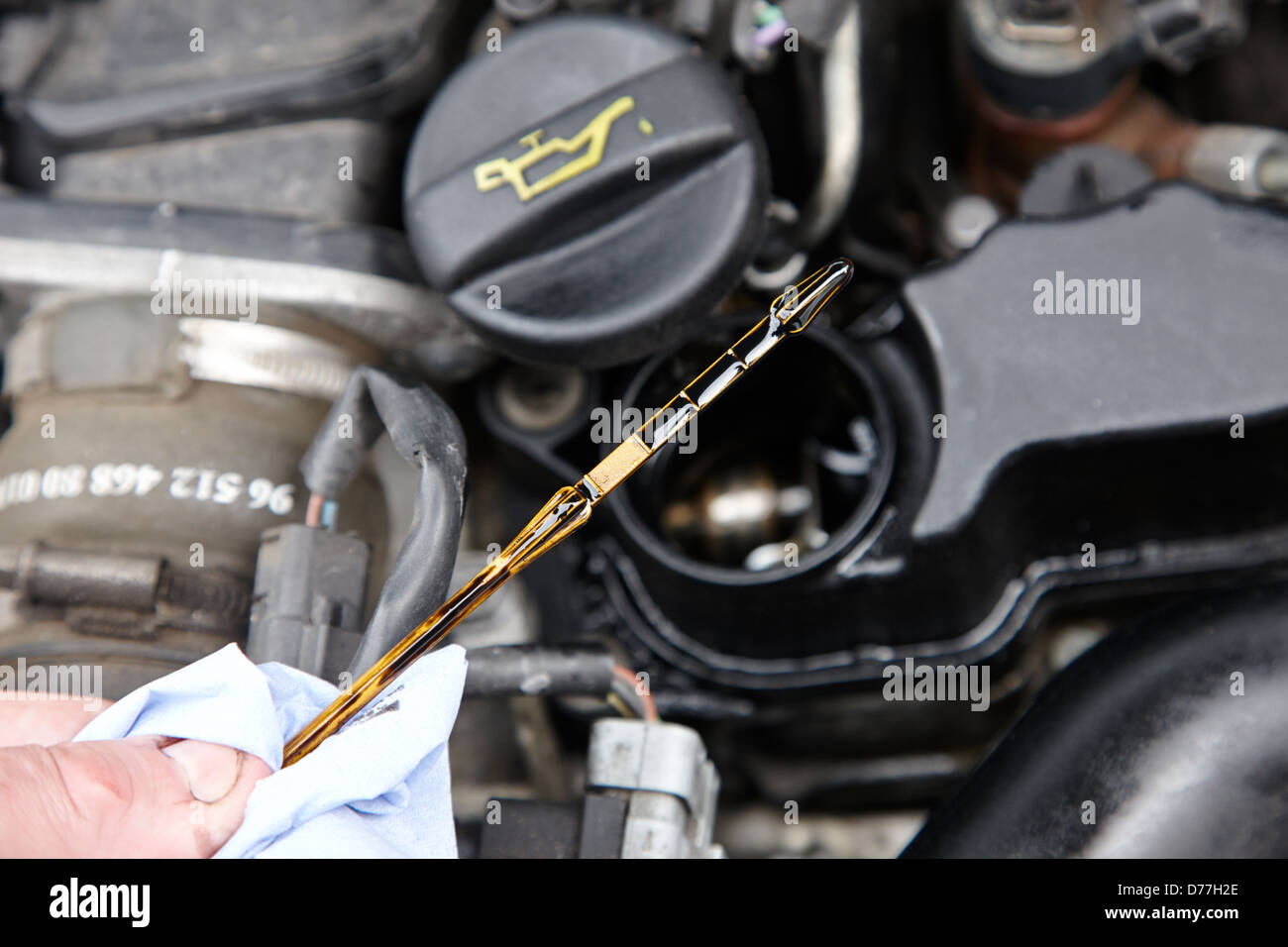 checking the oil level on the dipstick in a car engine compartment Stock Photo