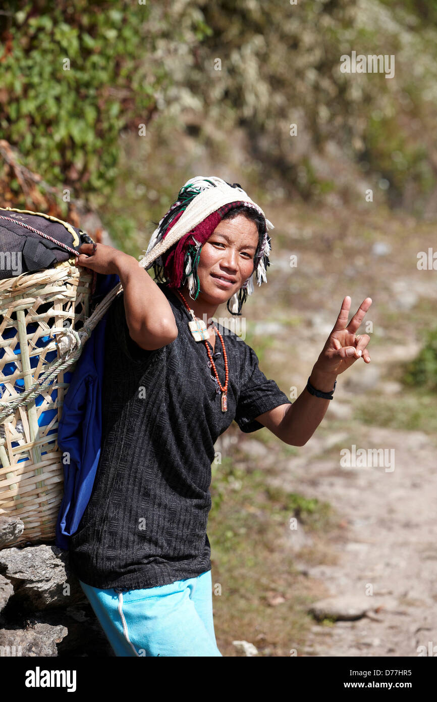 Nepal Himalaya female Sherpa porter carrying basket making peace sign Stock  Photo - Alamy