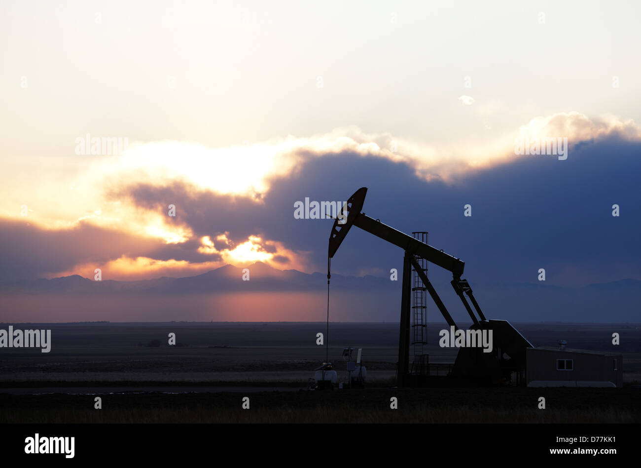 Oil well pumpjack pump jack at sunset eastern plains Colorado Longs