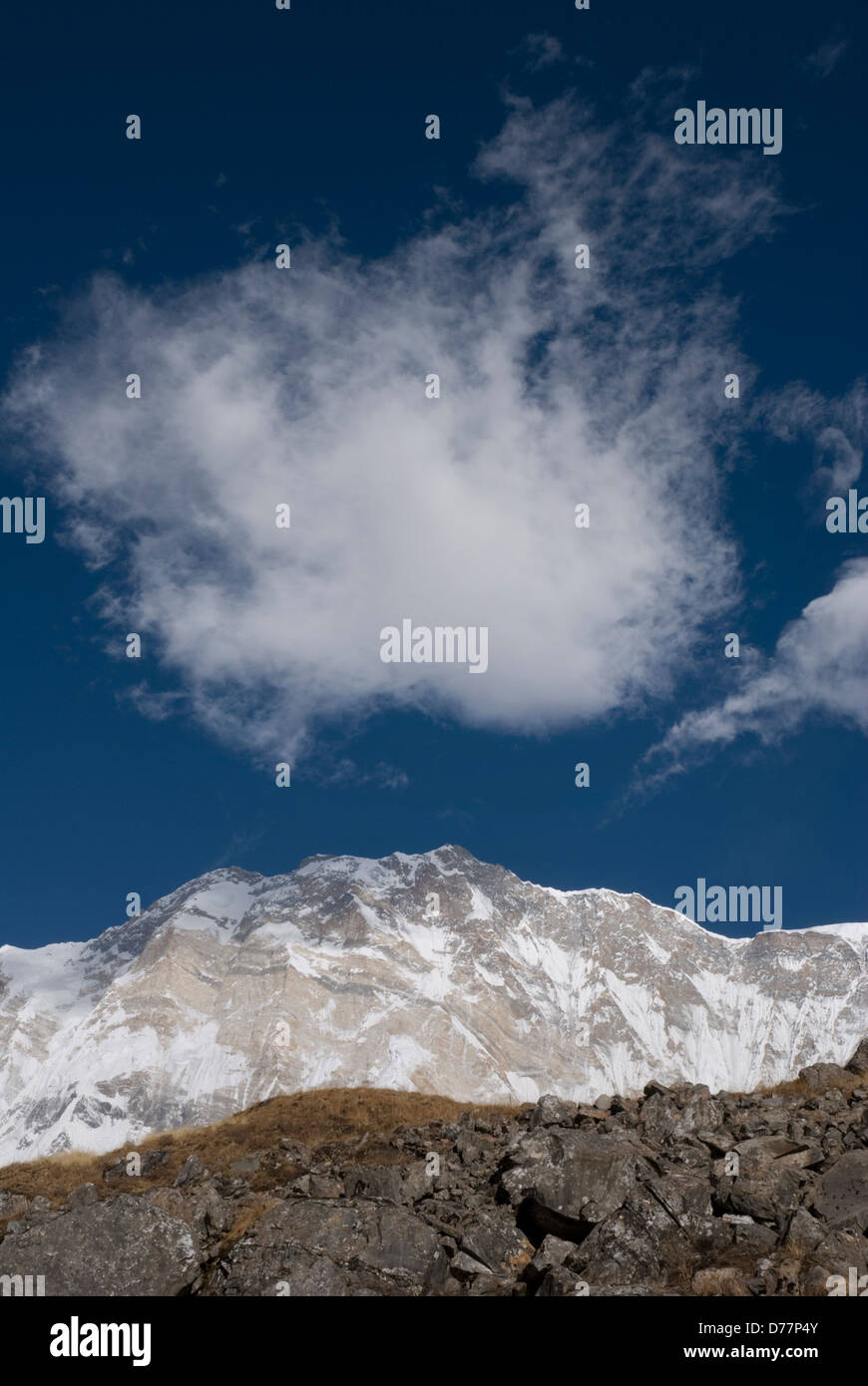 Fleecy clouds above snow covered mountain Annapurna range Himalayas, blue sky background, Nepal Stock Photo