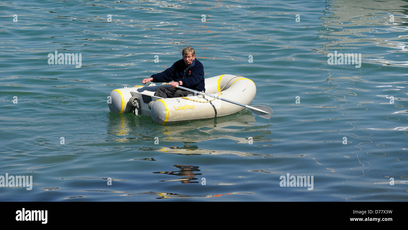 A man rowing in a rubber dinghy england uk Stock Photo