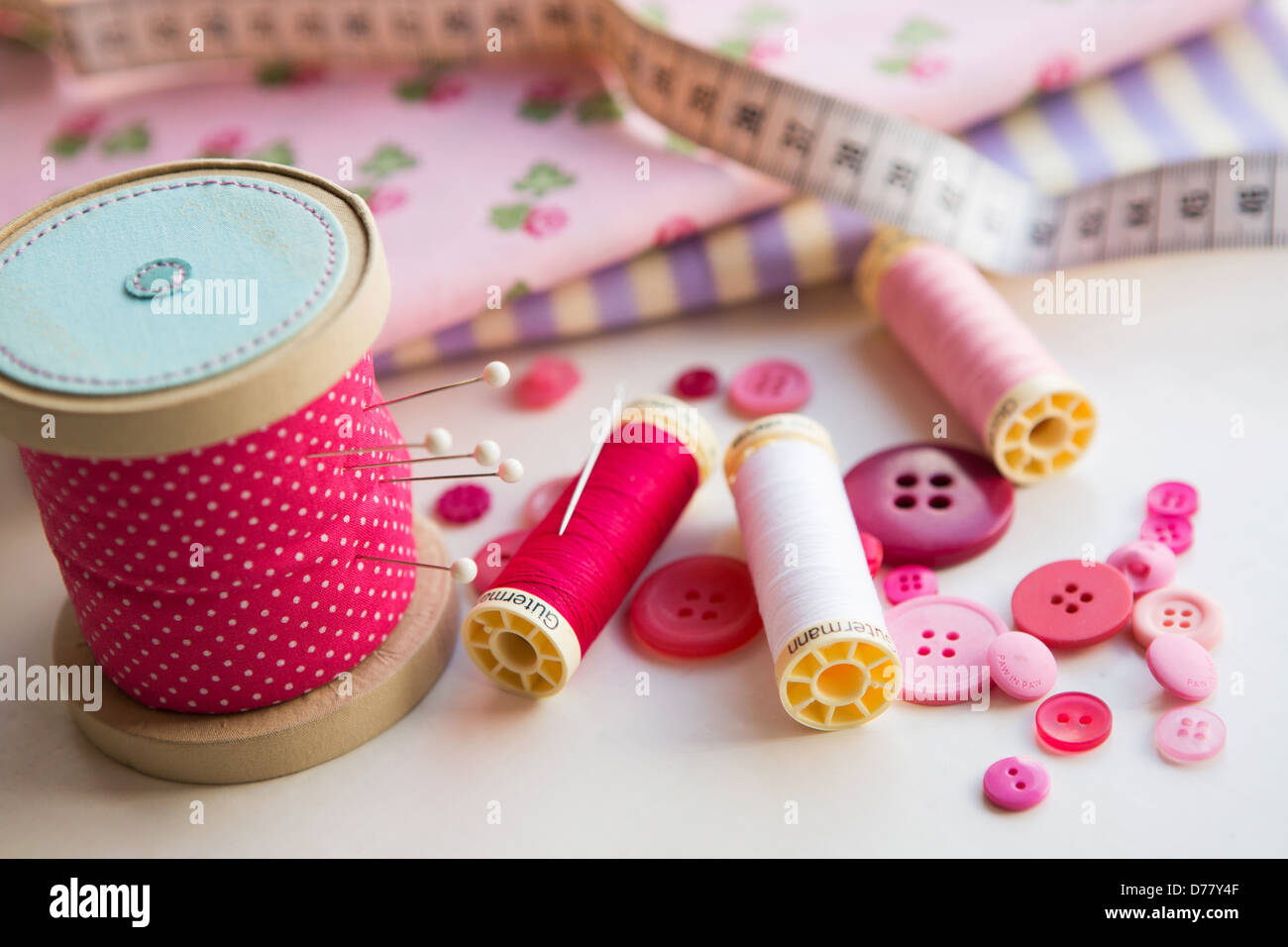 A sewing kit of thread, pins, pin cushion, fabric, tape measure and