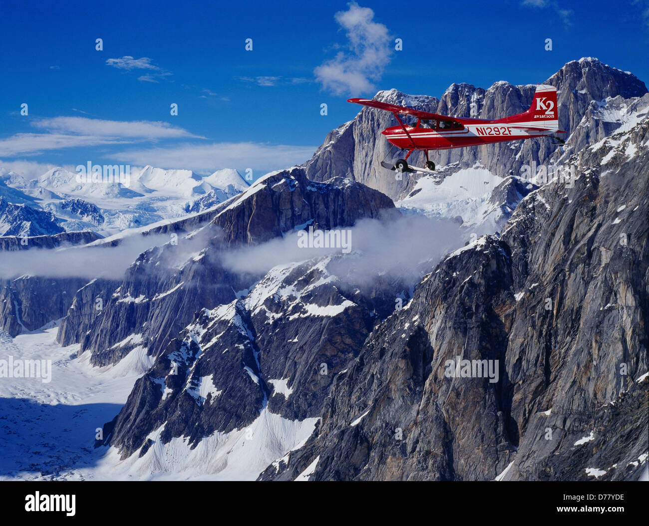 K2 Aviation's Cessna 185 on wheel skis flying up Ruth Gorge past Mooses Tooth Denali National Park Alaska. Stock Photo