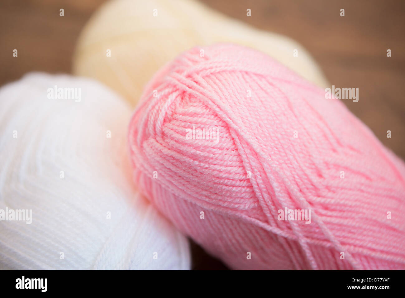 Three balls of wool placed on a wooden background Stock Photo