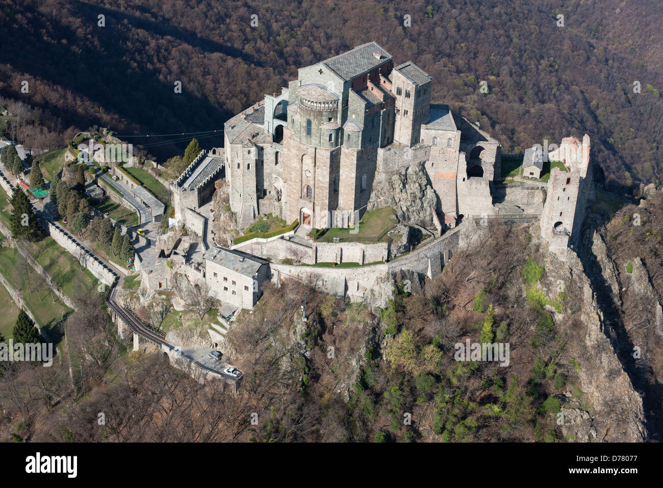 AERIAL VIEW. Abbey on a rocky promontory, high above the Susa Valley. Sacra di San Michele, Metropolitan City of Turin, Piedmont, Italy. Stock Photo