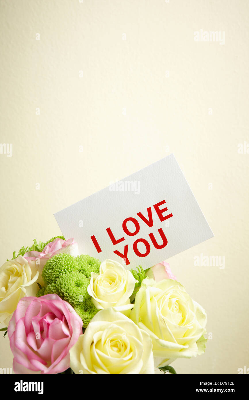 a bundle of flowers and a card saying i love you stock photo