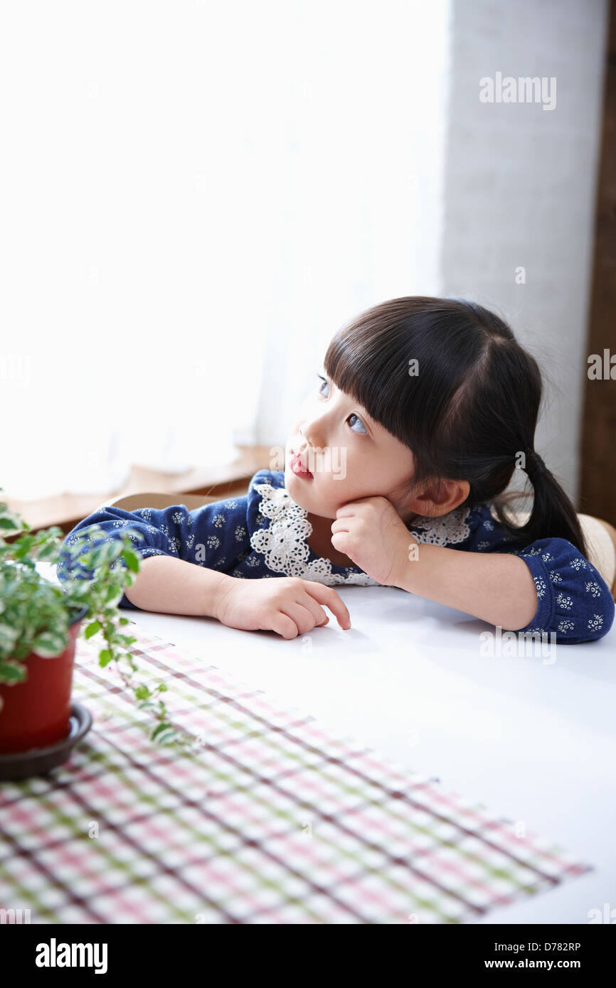 a girl sitting at table Stock Photo