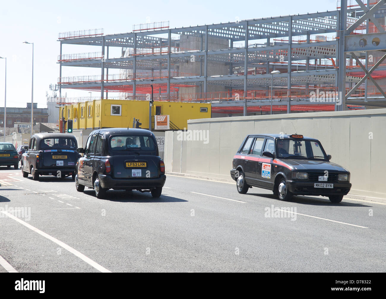 Taxis pass in front  of the under construction business and retail Quarter in Blackpool. Stock Photo