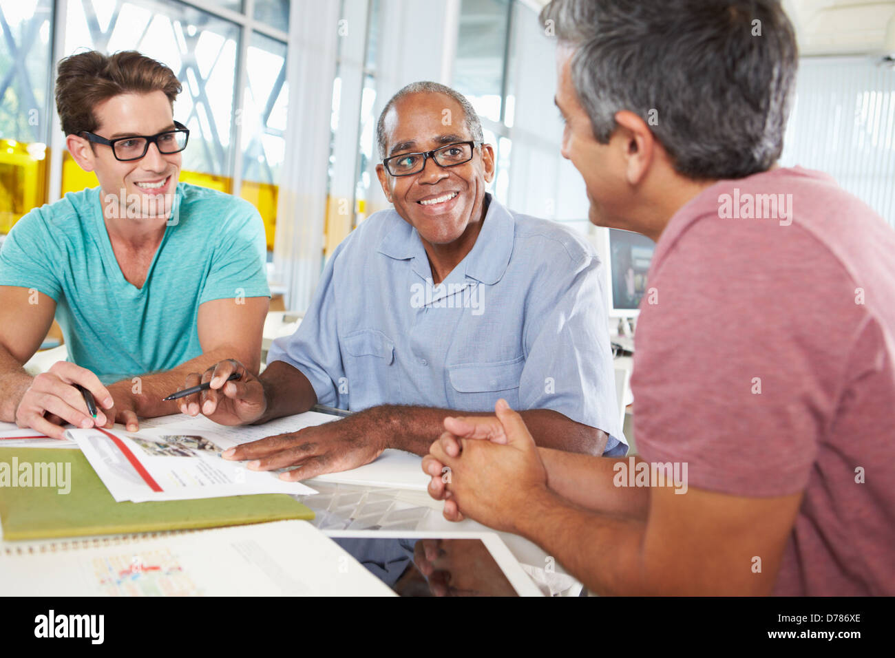 Group Of Men Meeting In Creative Office Stock Photo - Alamy