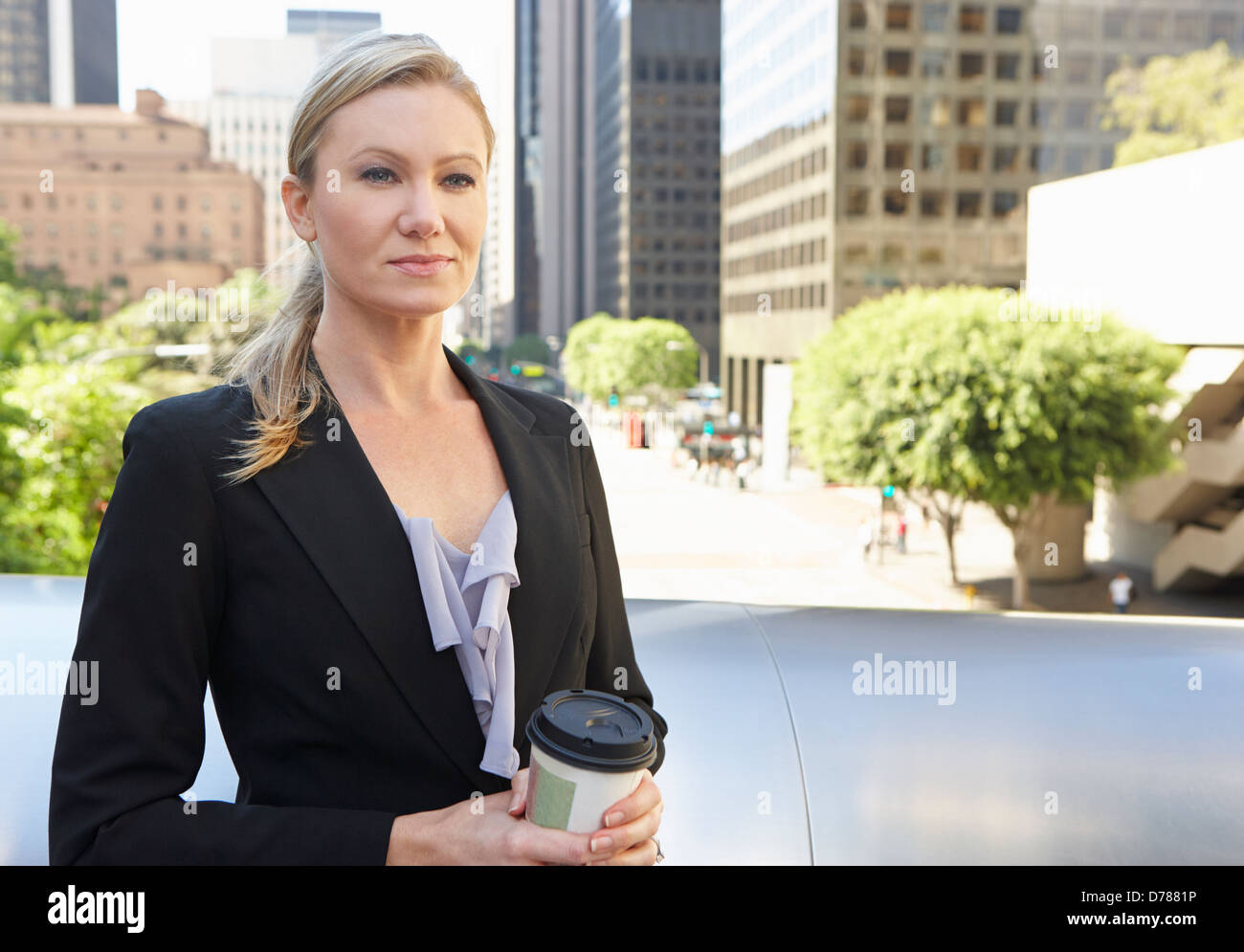 Businesswoman Drinking Takeaway Coffee Outside Office Stock Photo