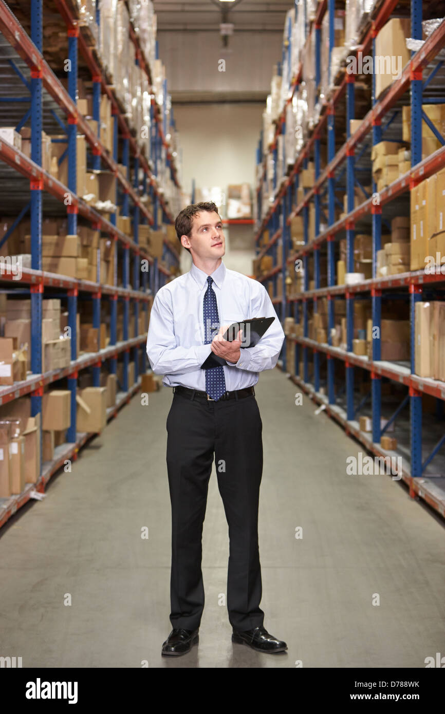 Manager In Warehouse With Clipboard Stock Photo