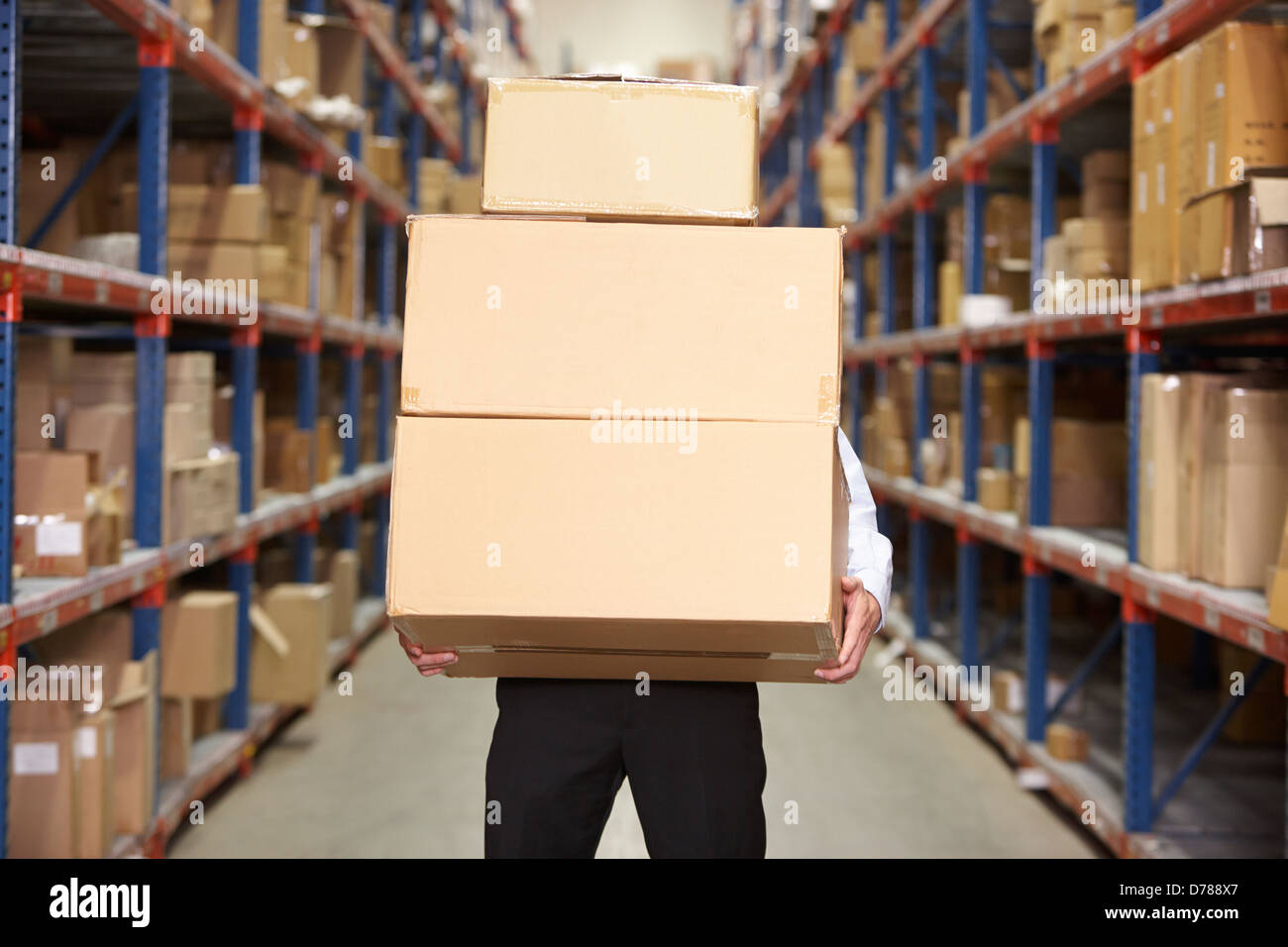 Man Carrying Boxes In Warehouse Stock Photo