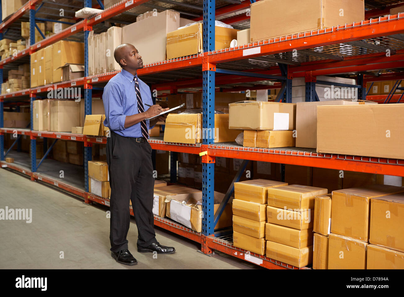 Businessman With Clipboard In Warehouse Stock Photo
