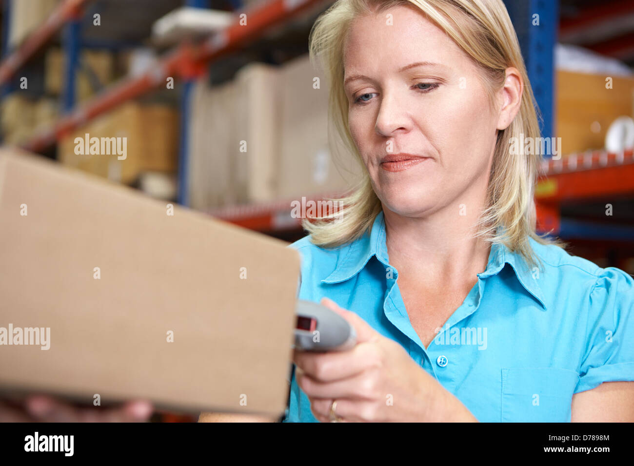 Businesswoman Scanning Package In Warehouse Stock Photo