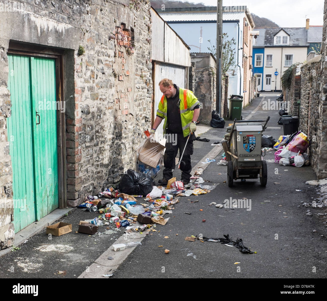 A council worker clearing rubbish strewn on the street from bin bags