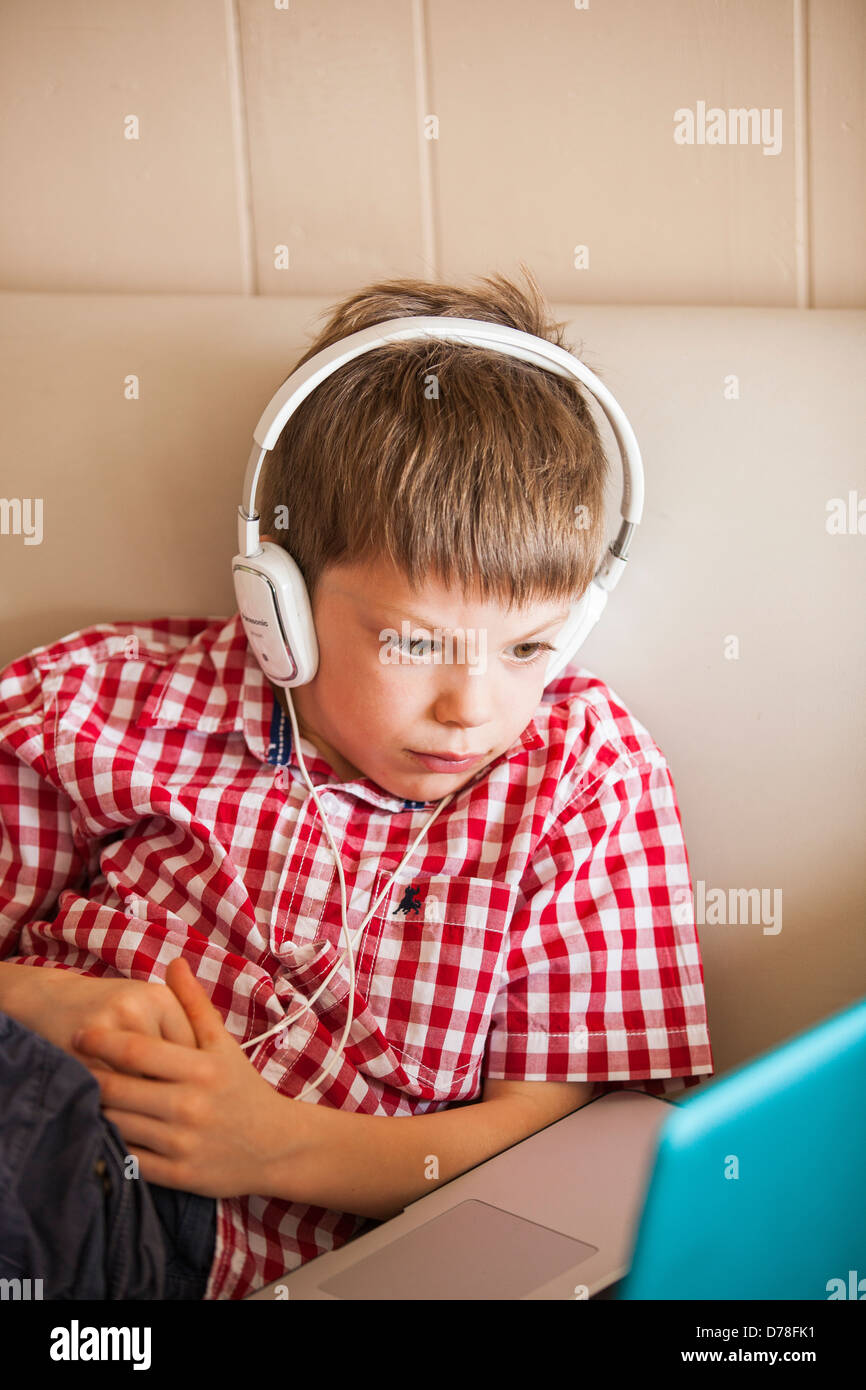 boy using laptop and headphones Stock Photo