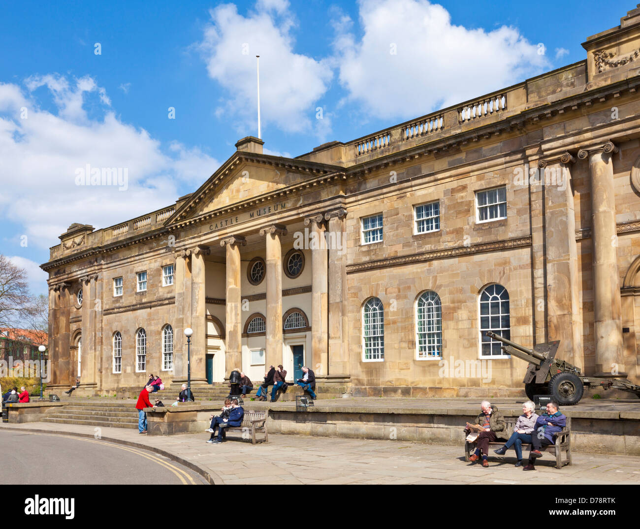Tourists sitting and waiting outside the York Castle Museum Eye of York or Castle Green York North Yorkshire England UK GB EU Stock Photo