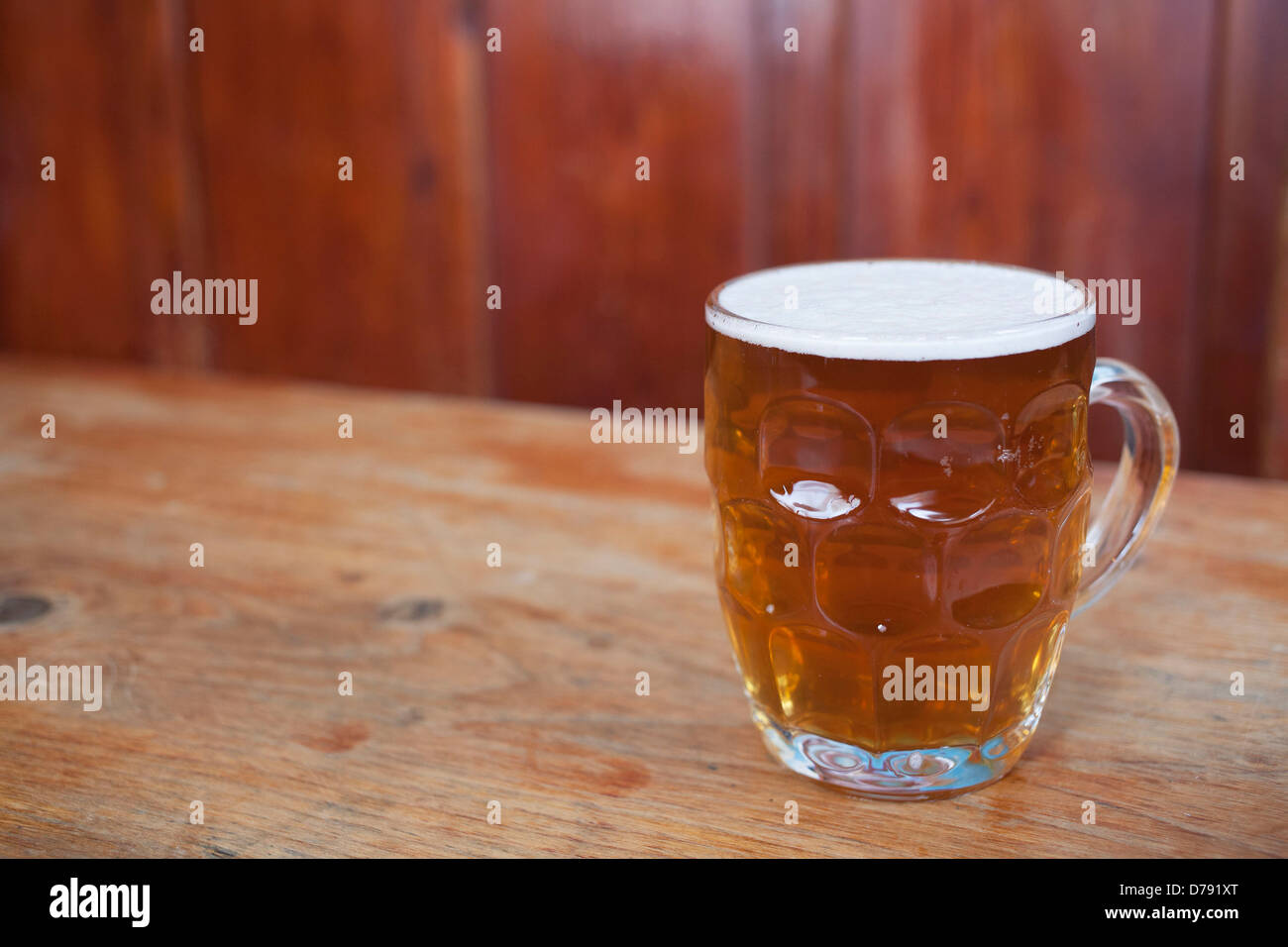 Pint of ale in an old fashioned jug beer glass. Stock Photo