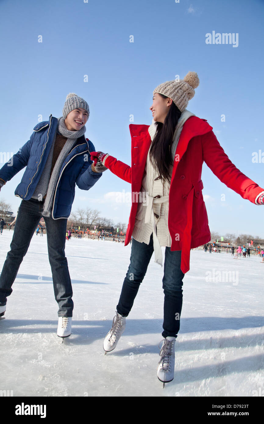 Young couple skating at ice rink Stock Photo - Alamy