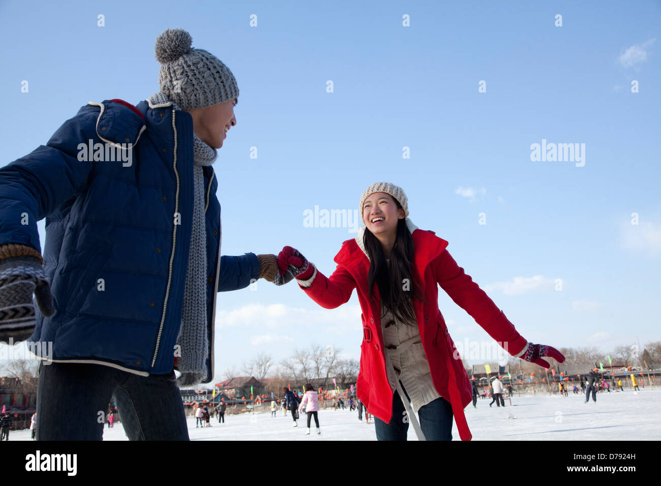 Young couple skating at ice rink Stock Photo - Alamy