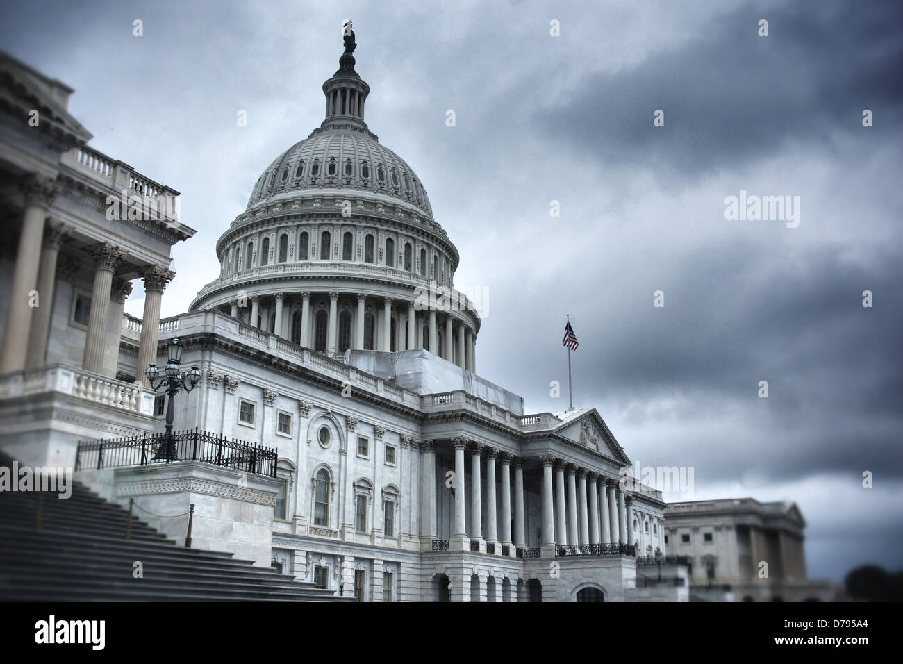 United States Capitol Building stands under a dark cloudy sky. Stock Photo