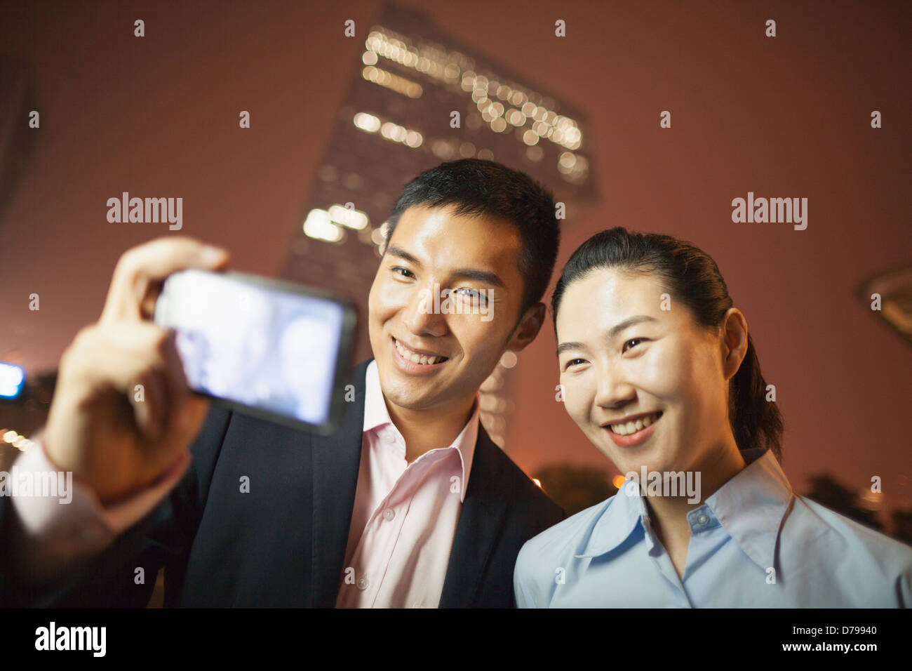 two business people smiling and taking a picture with the phone Stock