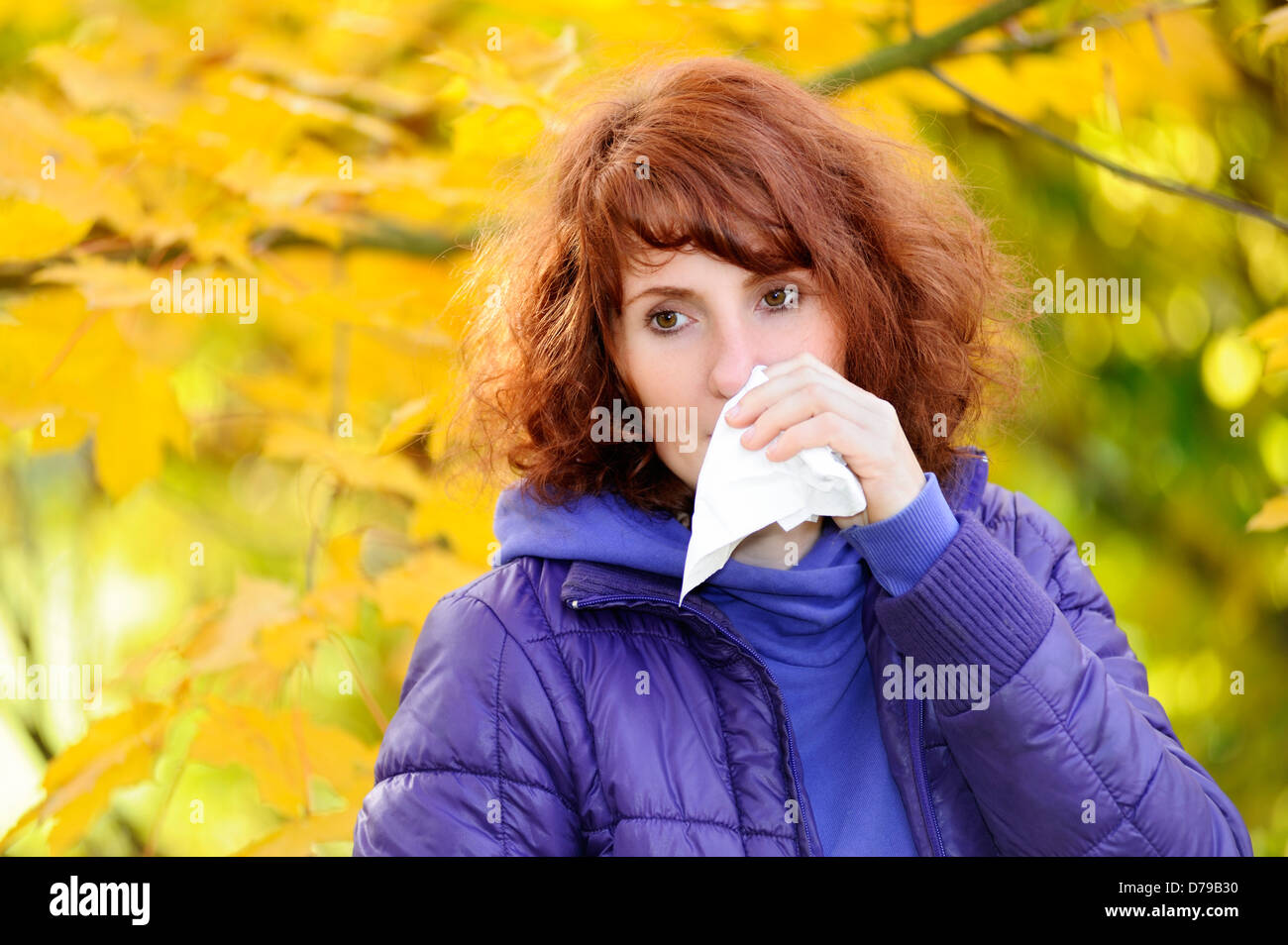 Woman with handkerchief in autumnal surroundings, cold , Frau mit Taschentuch in herbstlicher Umgebung, Erkältung Stock Photo