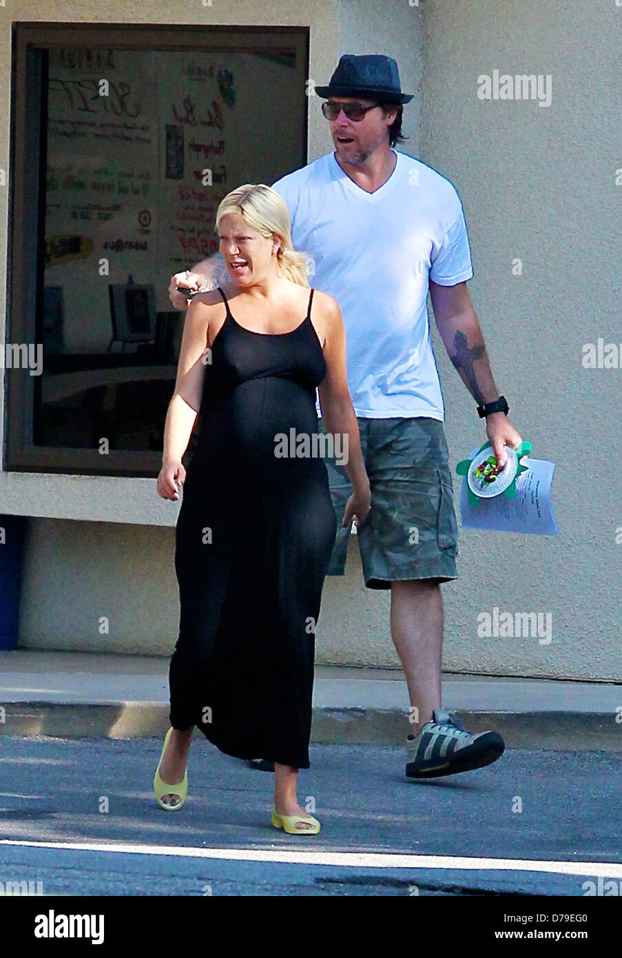 A heavily pregnant Tori Spelling, wearing no make up and her husband