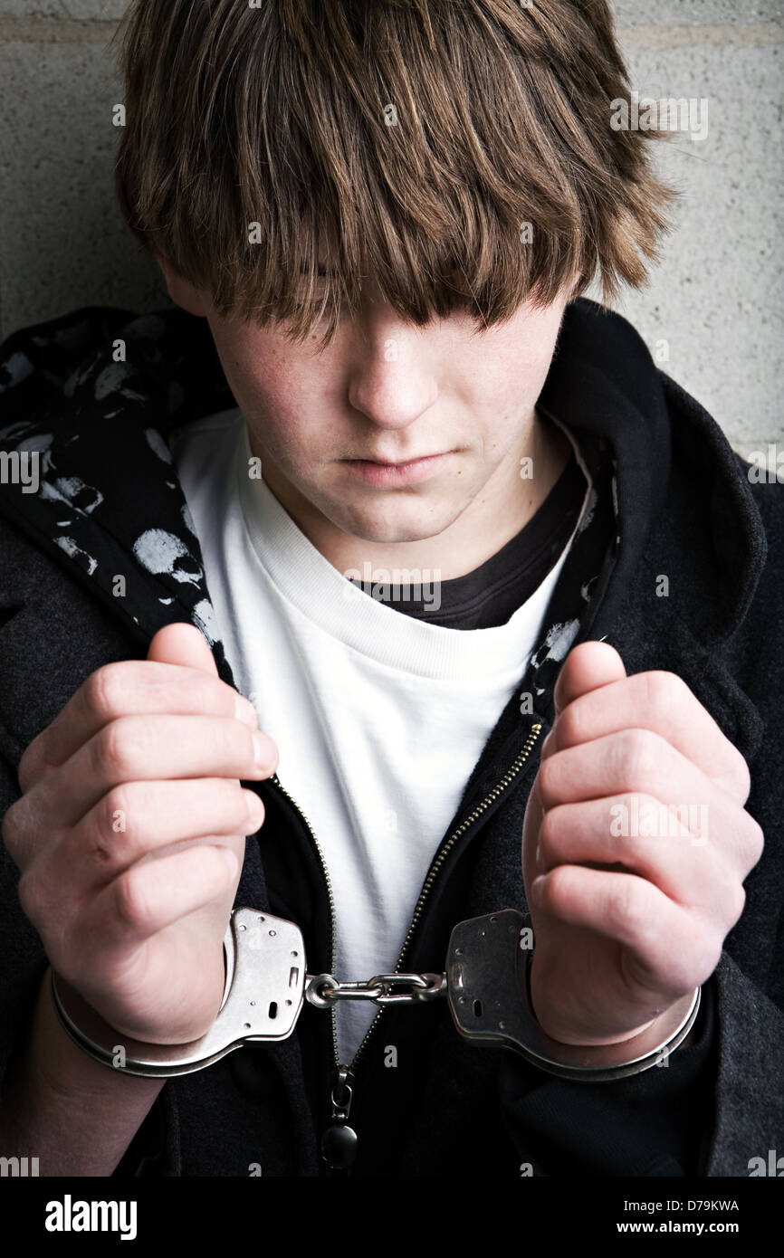 teen male portrait wearing handcuffs Stock Photo