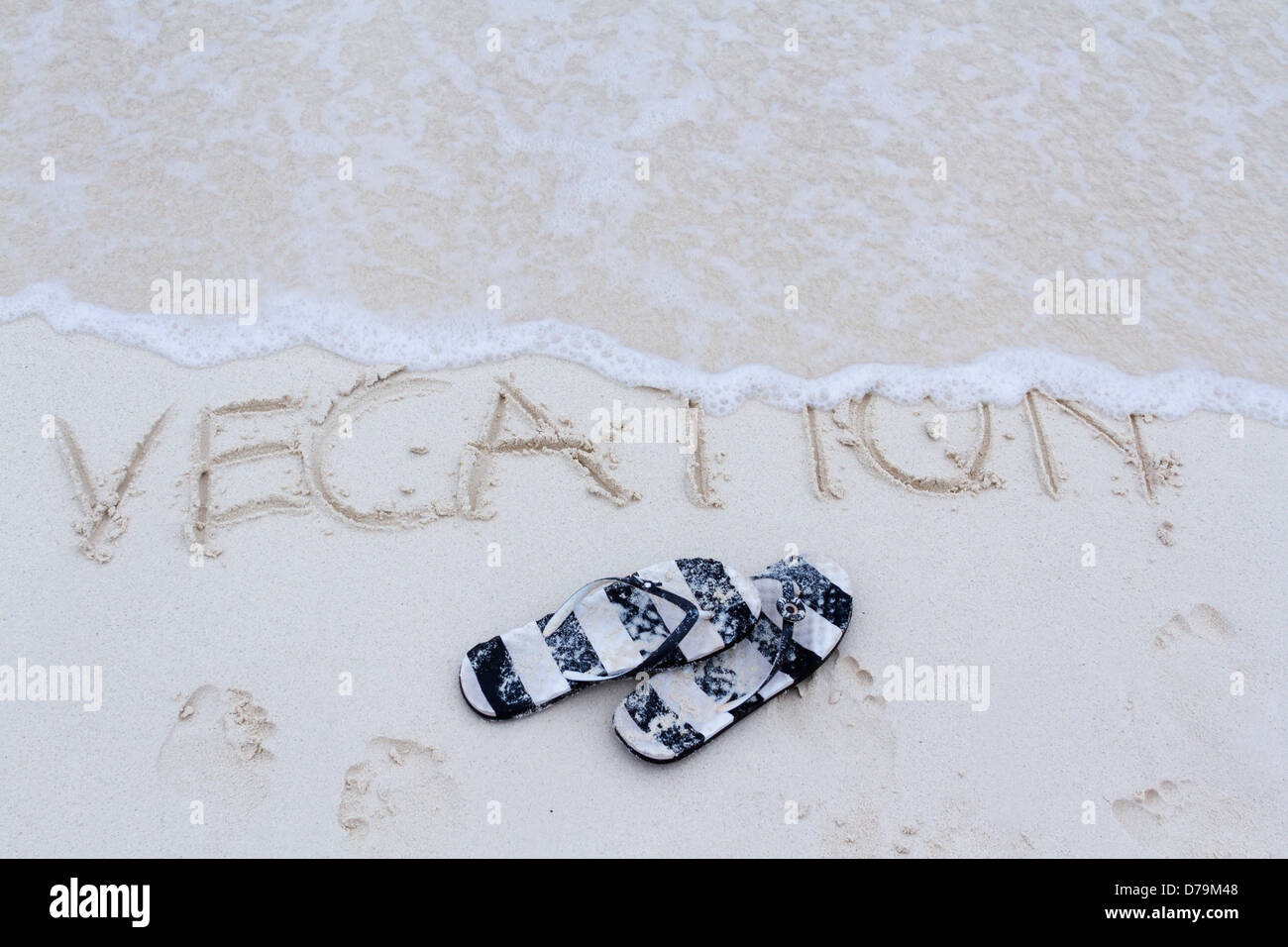 Vacation written on the beach with wave Stock Photo - Alamy