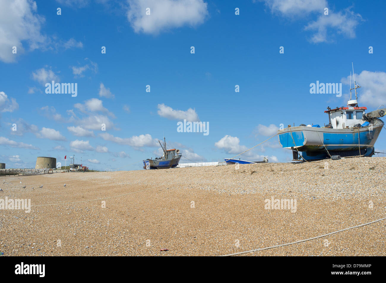 Fishing boats pulled up the beach and above the high tide line at Hythe, Kent, UK Stock Photo