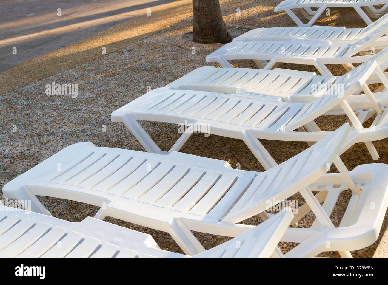 White pool chairs near the swimming pool at vacation resort in Mexico