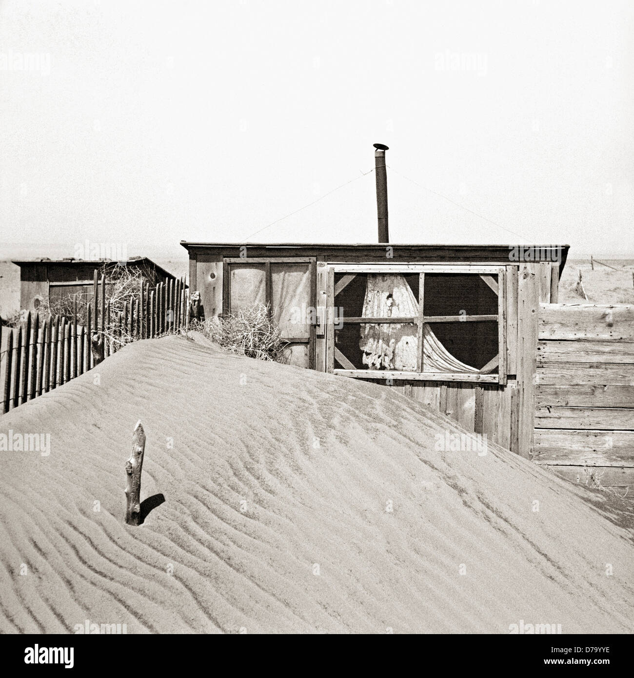 Sand Piled Against Outhouse Stock Photo