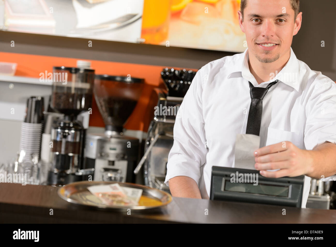 Handsome smiling male waiter giving receipt czech crowns in pub Stock Photo