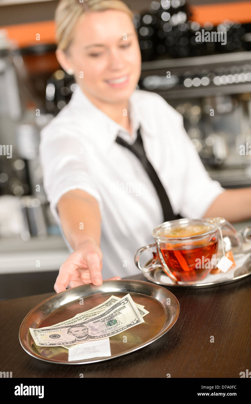 Attractive waitress taking tip in bar from tray american dollar Stock Photo