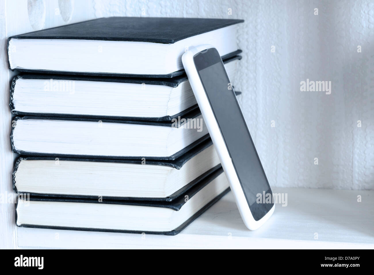 stack of five books on the white shelf with new tablet pc Stock Photo