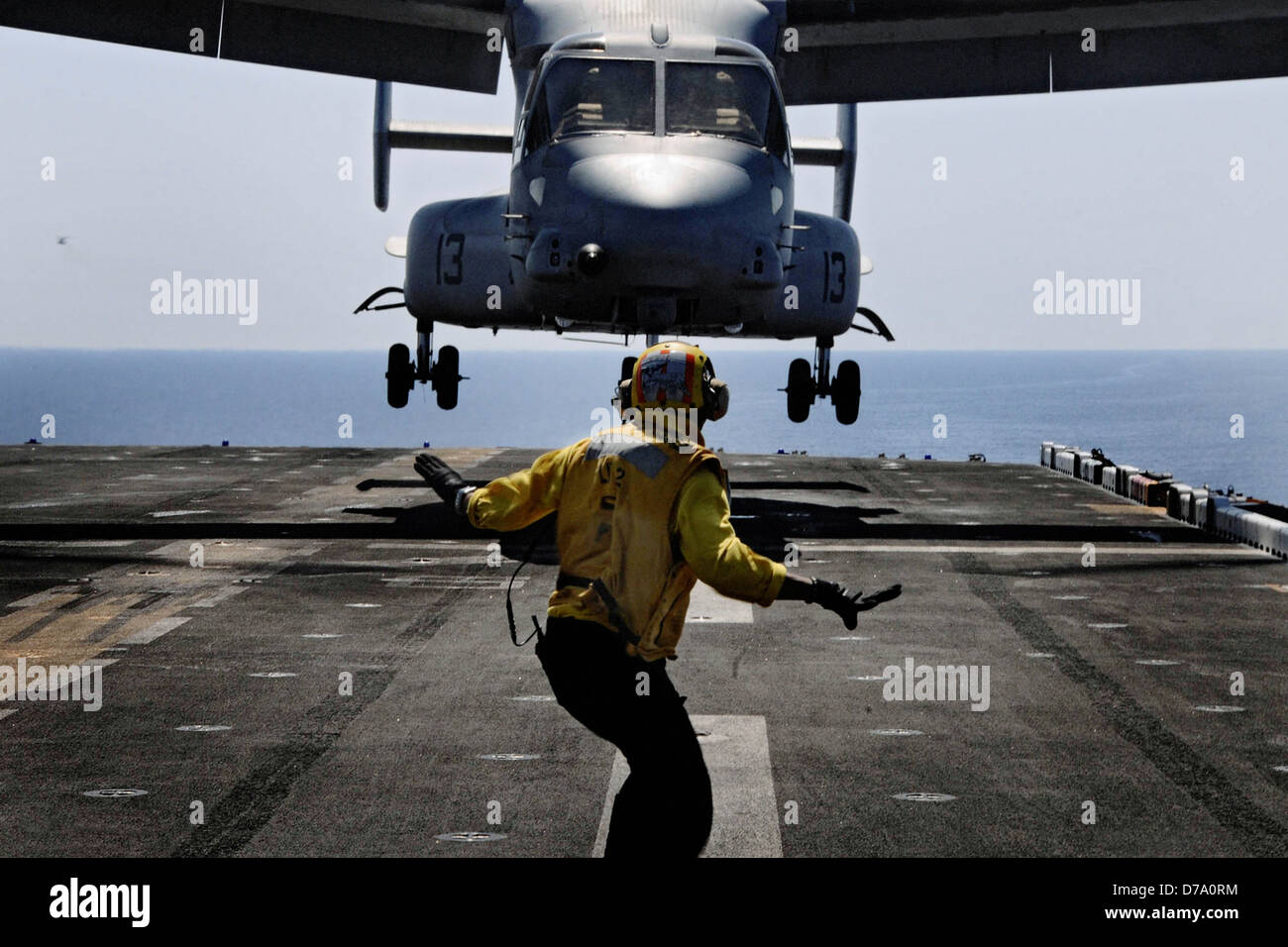 Landing Signalman Guides Osprey Onto Flight Deck Stock Photo