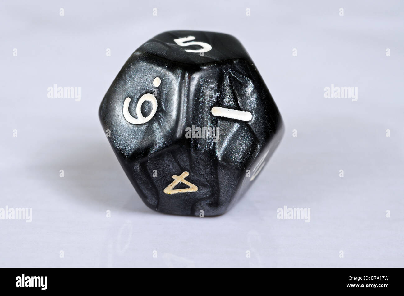 Platonic dodecahedron 12 sided die against a grey background. Stock Photo