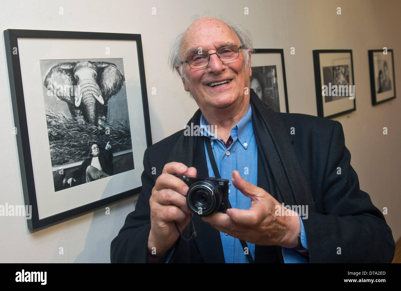 Spanish film director Carlos Saura poses with camera during the exhibition of his photographs in Instituto Cervantes in Prague, Czech Republic, April 30, 2013. (CTK Photo/Vit Simanek) Stock Photo