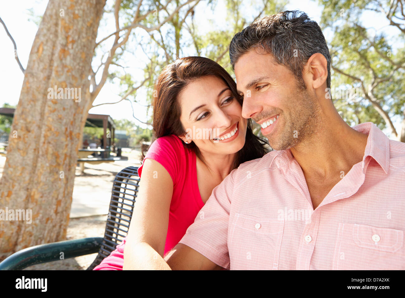 Romantic Couple Sitting On Park Bench Together Stock Photo - Alamy