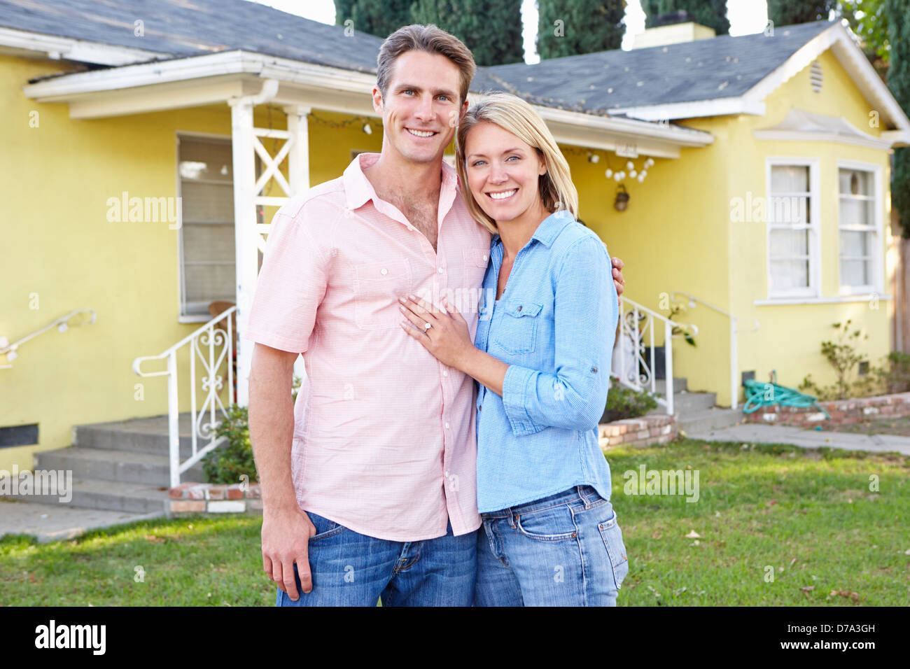 Couple Standing Outside Suburban Home Stock Photo